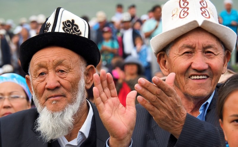 Local men clapping and cheering at the World Nomad Games in Kyrgyzstan