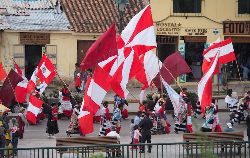 Local parade demonstration in Cusco, Peru with flags on display 