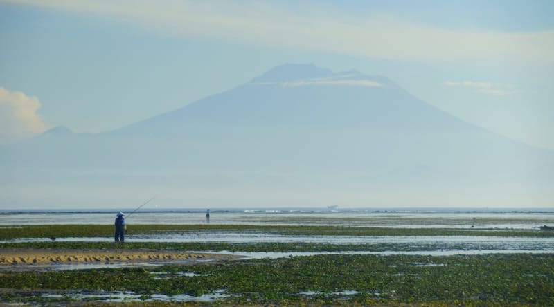 Local fishing with mountain volcano backdrop in Sanur, Bali, Indonesia 