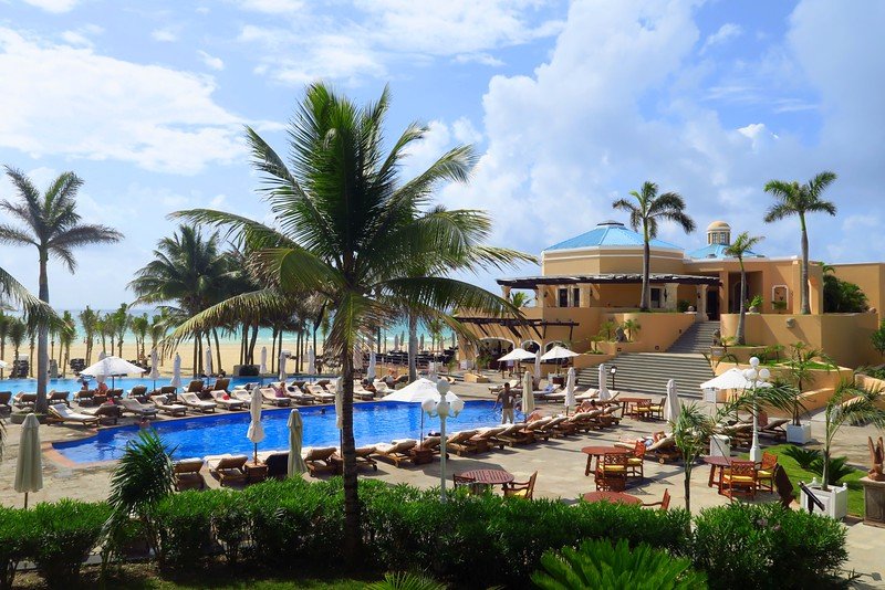 Luxury beachfront resort Royal Hideaway with palm trees, pool, and sun loungers at Playa del Carmen, Mexico overlooking the Caribbean Sea