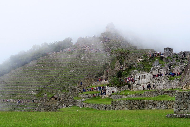 Machu Picchu covered in fog from a low level vantage point is typical weather when visiting this most famous attraction in Peru 