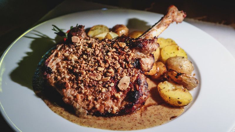 Main dish Pork chop covered in walnuts at Modrá Hviezda with roasted potatoes as a side dish in Bratislava, Slovakia Main dish Pork chop covered in walnuts at Modrá Hviezda with roasted potatoes as a side dish in Bratislava, Slovakia