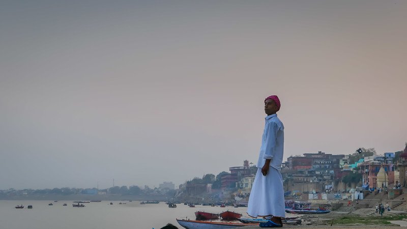 Man watching the sunset in Varanasi with old world charm and views that seem as old as the earth itself in India