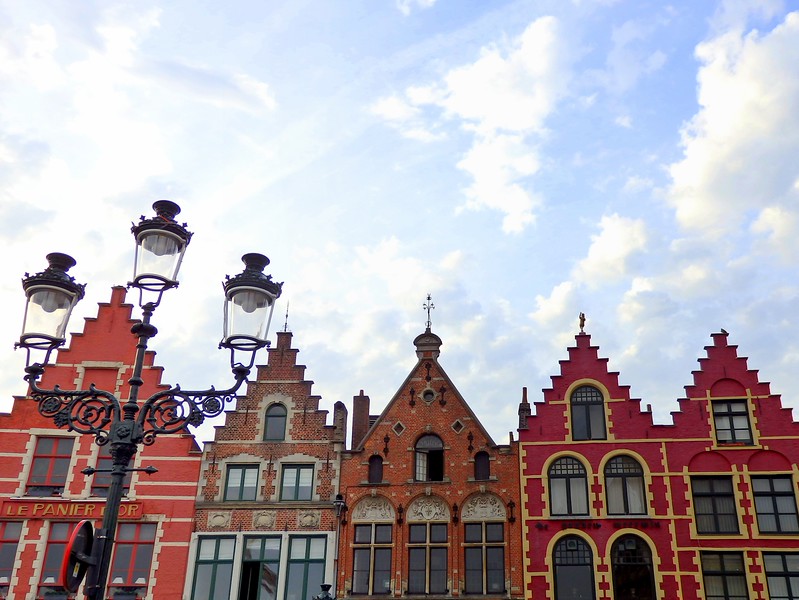 Market Square in Bruges has colourful orange, red and brown buildings with distinct architecture Market Square in Bruges has colourful orange, red and brown buildings with distinct architecture