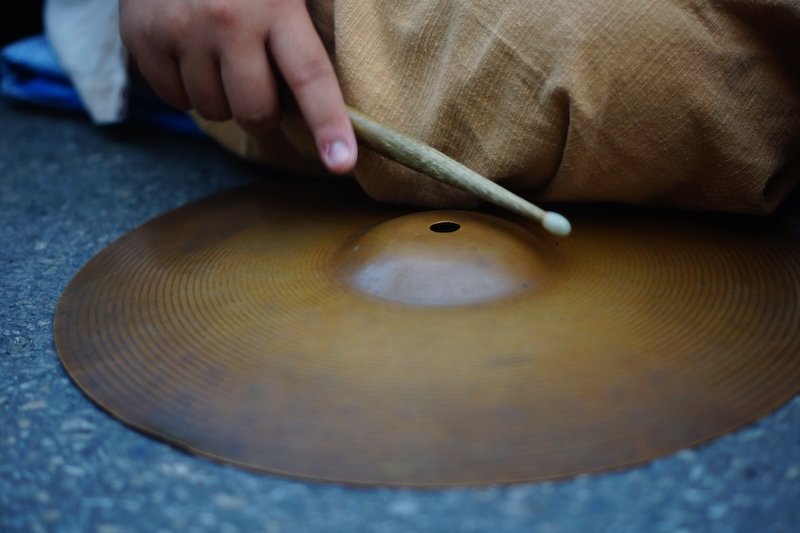 Music being played with a symbol and wooden stick at the Chiang Mai Saturday Night Market in Thailand 