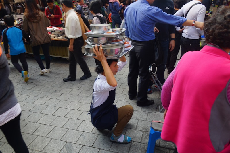Myeongdong with a Korean lady carrying food on her head in Seoul, South Korea 
