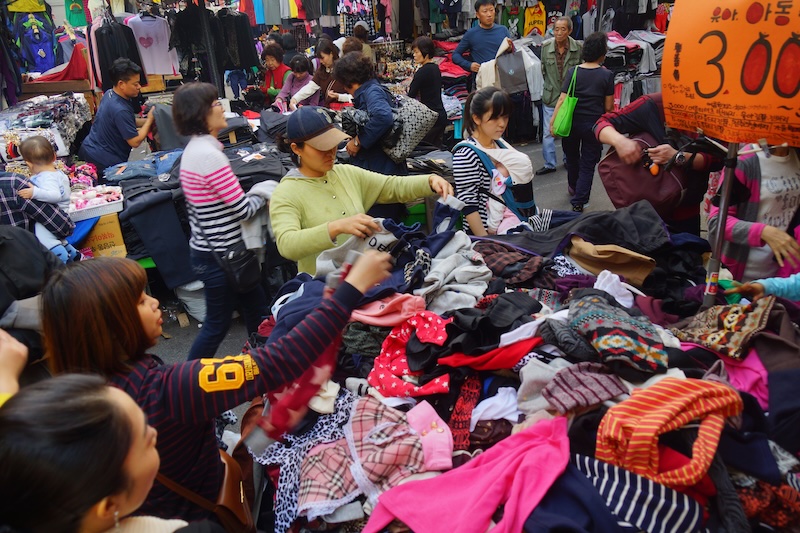 Namdaemun Korean discount shoppers buying clothes from a huge pile in Seoul, Korea 