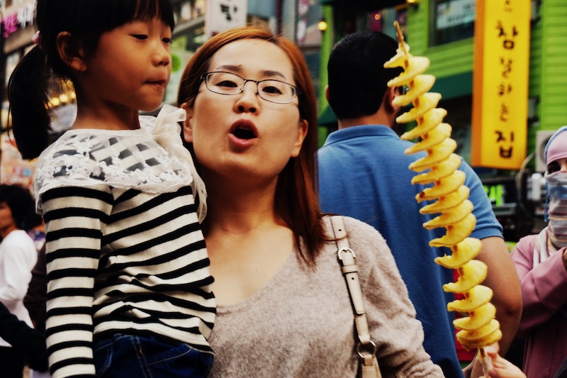 Namdaemun Korean lady and daughter eating tornado chips in Seoul, Korea 