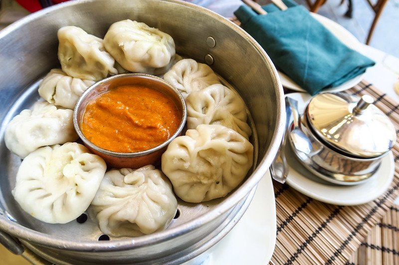 Traditional Nepali momos served with spicy tomato dipping sauce at a local restaurant in Kathmandu, Nepal