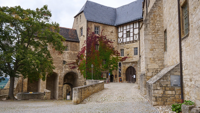Neuenburg Castle in Freyburg, Germany with views of the the cobblestone path leading to a building covered partially in ivy 