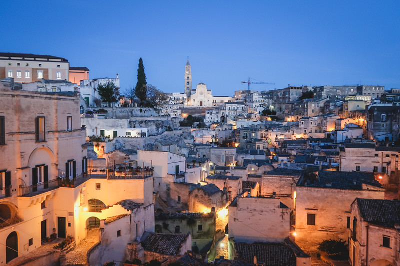 Nighttime views of Matera, Italy during blue hour with all of the buildings lit up and on display Nighttime views of Matera, Italy during blue hour with all of the buildings lit up and on display