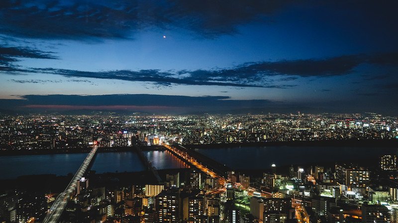 Nighttime views of Osaka, Japan from a high vantage point overlooking the modern skyline and bridges 