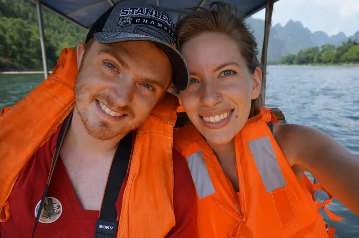 Nomadic Samuel and That Backpacker cruising down the Li River in China wearing lifejackets and smiling enjoying the experience thoroughly 