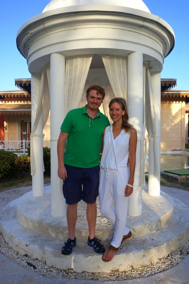 Nomadic Samuel and Audrey Bergner That Backpacker posing together at a Cuban resort gazebo during their honeymoon, showcasing stylish yet comfortable travel clothing for a tropical getaway