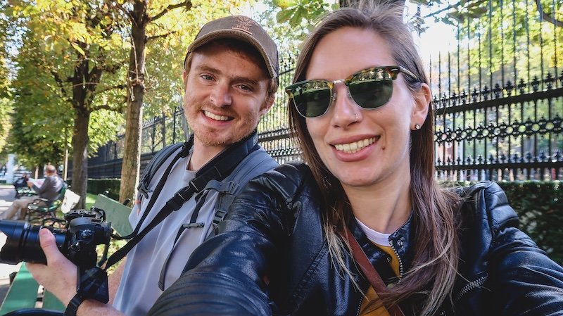 Nomadic Samuel and Audrey Bergner of That Backpacker smiling on a sunny day in Vienna, sitting on a park bench with a camera in hand, ready to explore the city’s attractions Nomadic Samuel and Audrey Bergner of That Backpacker smiling on a sunny day in Vienna, sitting on a park bench with a camera in hand, ready to explore the city’s attractions