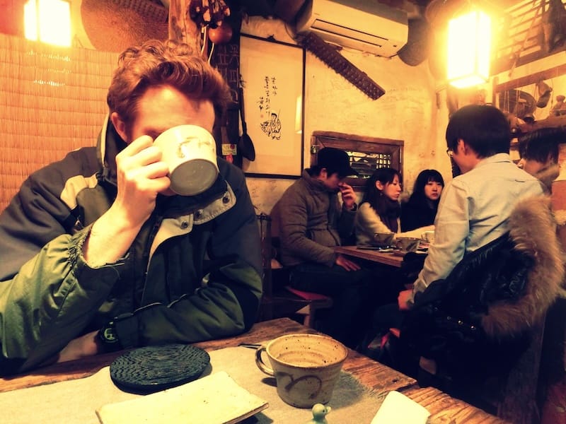 Nomadic Samuel drinking Korean tea on a cold winter day in Seoul wearing a thick winter jacket in Insadong, South Korea 