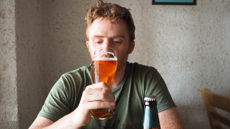 Nomadic Samuel enjoying a pint of beer at Karakol, Kyrgyzstan 