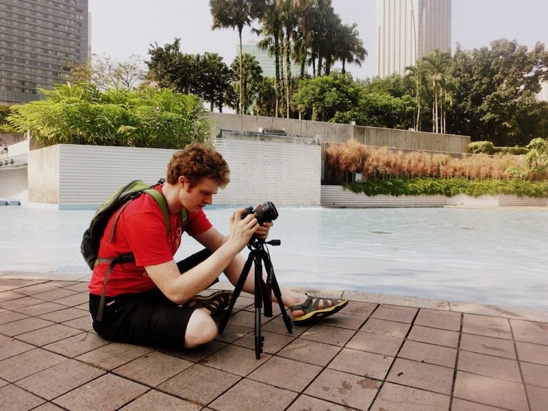 Nomadic Samuel filming in Kuala Lumpur setting up the tripod in Malaysia 