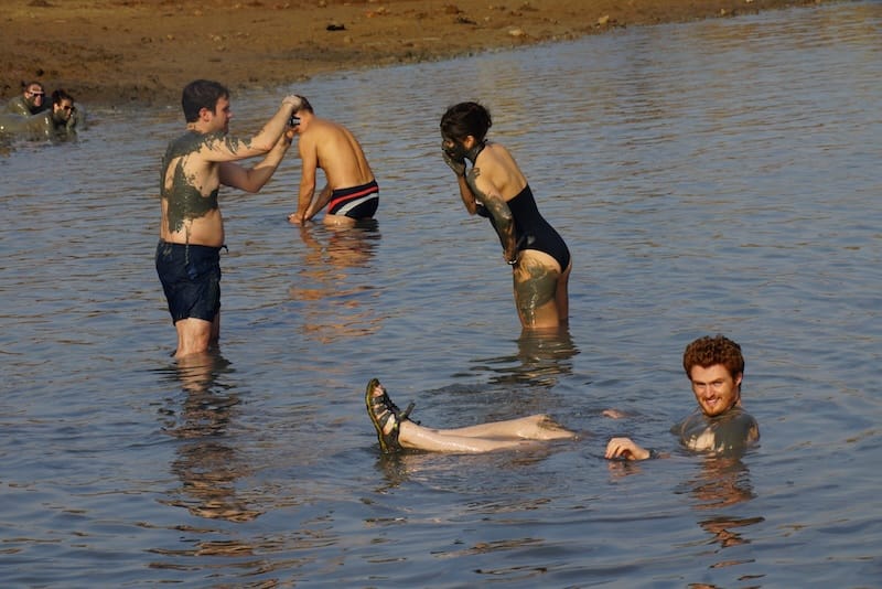 Nomadic Samuel floating in the Dead Sea with other tourists in Israel 