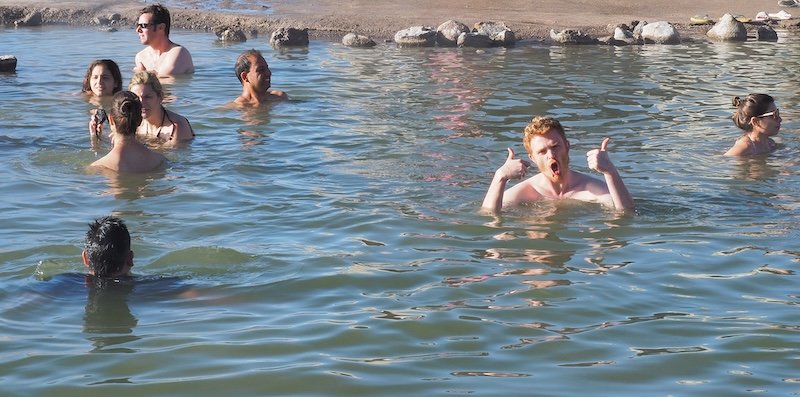 Nomadic Samuel enjoying the thermal hot springs near El Tatio Geysers in the Atacama Desert, Chile, giving two thumbs up in the warm mineral waters