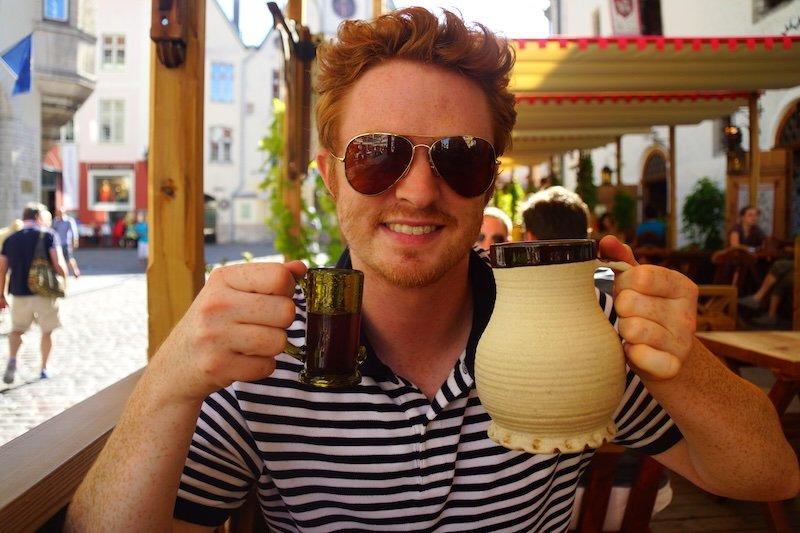 Nomadic Samuel enjoying medieval drinks at Olde Hansa restaurant in Tallinn, Estonia during a day trip from Helsinki