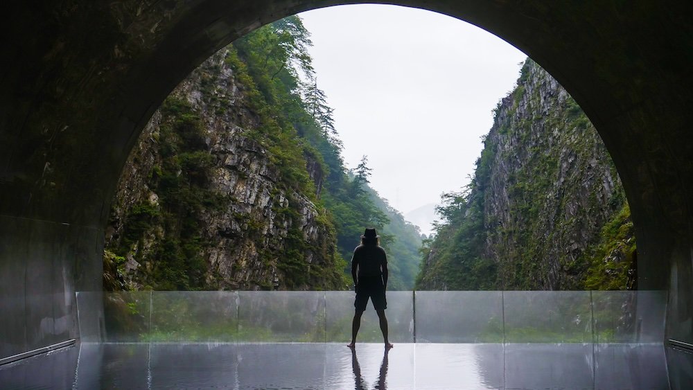 Nomadic Samuel posing by the reflection pool at Kiyotsu Gorge, Japan Nomadic Samuel posing by the reflection pool at Kiyotsu Gorge, Japan