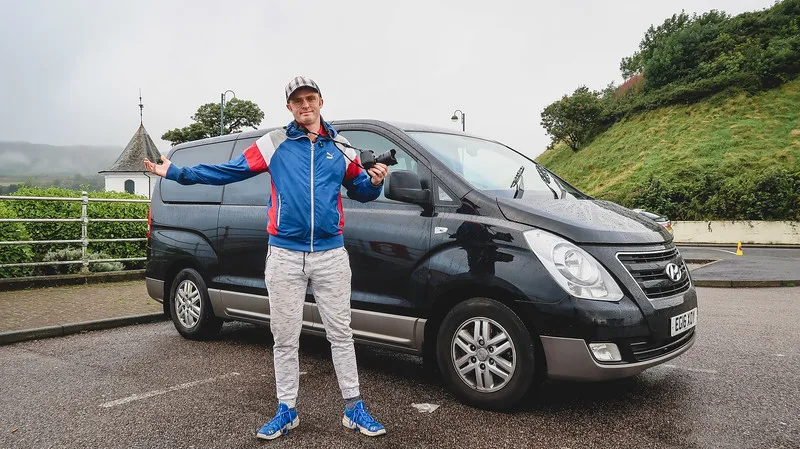 Nomadic Samuel posing with our rental car in Scotland that we used to get to Dunoon