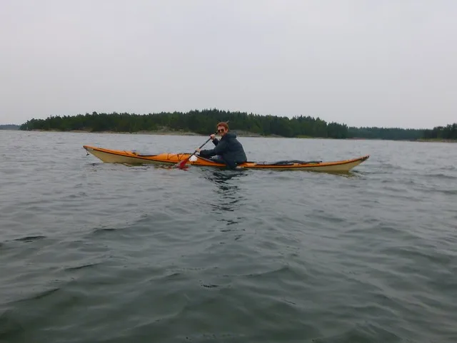 Nomadic Samuel Sam sea kayaking in the Archipelago Sea in Finland with a smile on his face enjoying the adventure outdoors  