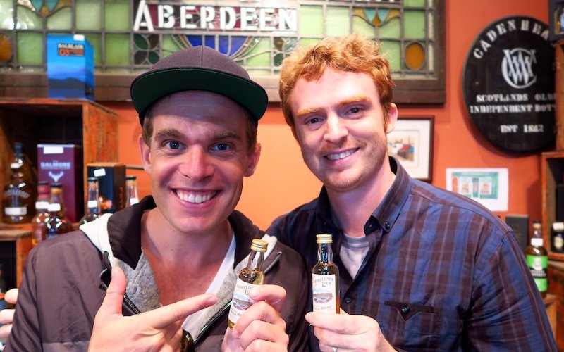 Nomadic Samuel and SHABL Rob holding whisky miniatures at Cadenhead’s Whisky Shop in Edinburgh, Scotland during Eat Walk Edinburgh food tour