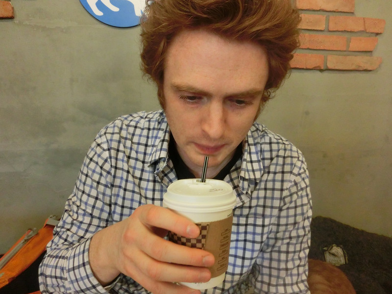 Nomadic Samuel sipping on a drink at the cat cafe in Hongdae neighbourhood in Seoul, South Korea 