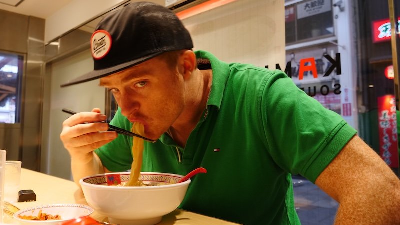 Nomadic Samuel slurping noodles with gusto in Osaka, Japan 
