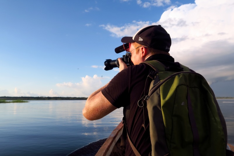 Nomadic Samuel taking photos and filming while enjoying an Amazon jungle adventure in Peru 