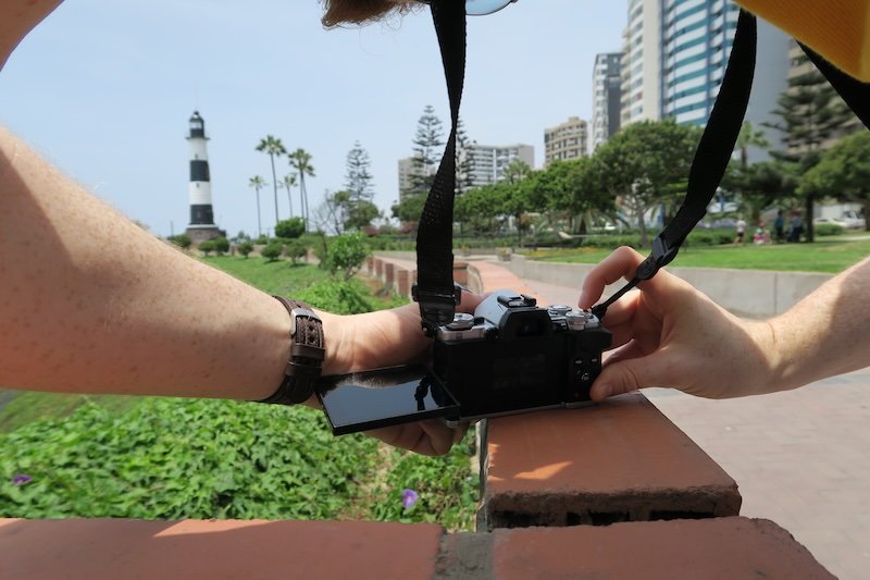 Nomadic Samuel taking photos of the iconic lighthouse in Lima, Peru 