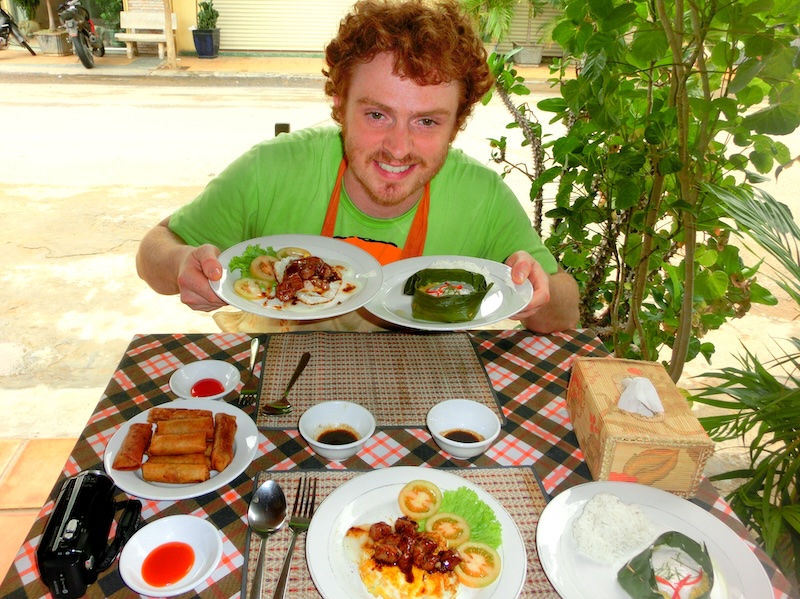 Nomadic Samuel thrilled to be finally eating after learning how to cook at Nary Kitchen in Battambang, Cambodia 