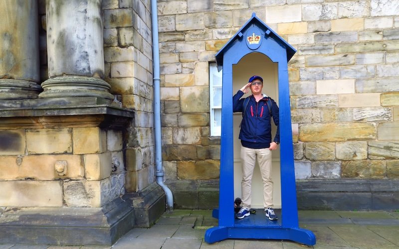 Nomadic Samuel visiting Edinburgh during autumn when jacket and hats are appropriate for walking outside 