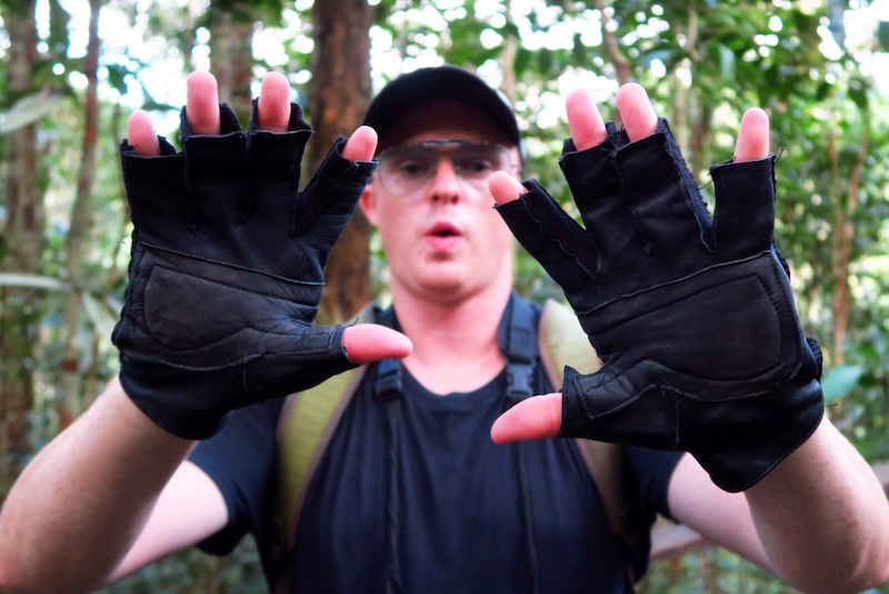 Nomadic Samuel wearing travel gloves in the Amazon Forest of Peru 