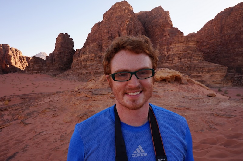 Nomadic Samuel with camera dangling around his neck in Wadi Rum, Jordan 