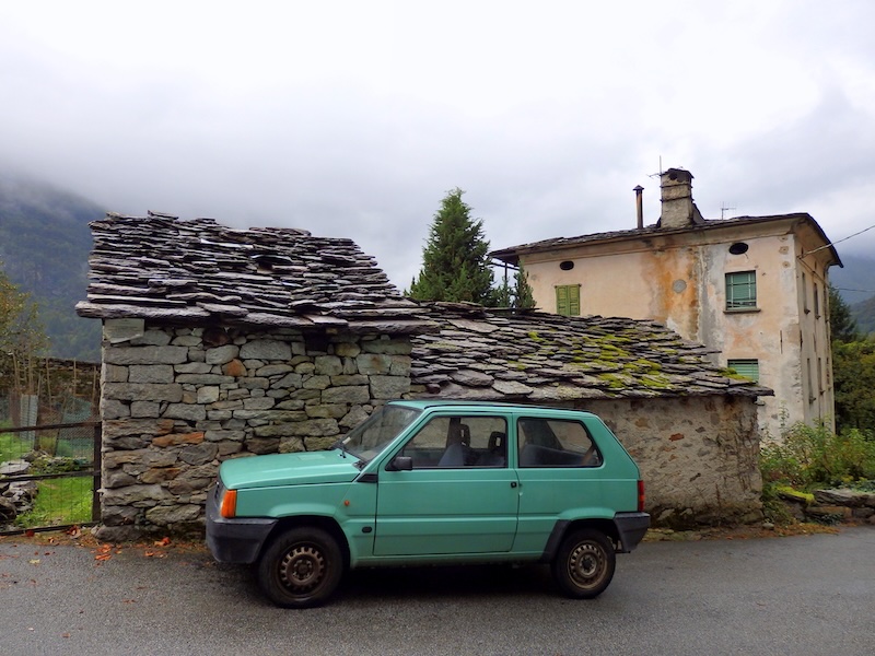 Old car parked beside an old building in Chiavenna, Italy 