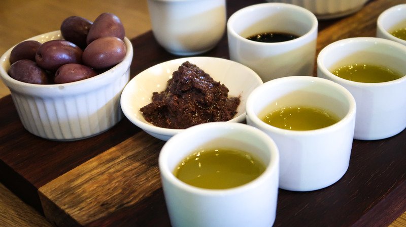 Olive oil tasting at Tokara in Stellenbosch, South Africa in dishes with whole olives, crushed olives and actual olive oil for tasting pleasure