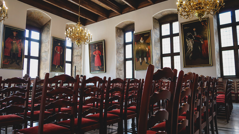 One of the halls in the Historical Museum in Gdansk, Poland featuring regal chairs and distinct paintings 