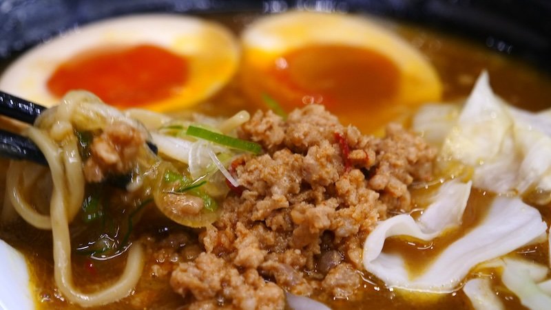 Osaka ramen macro details of the meat, eggs and vegetables and noodles in the bowl in Japan 