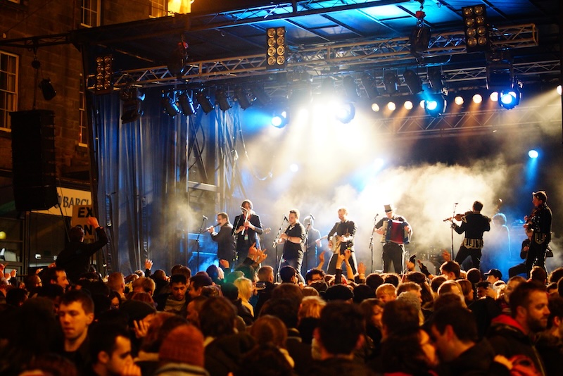 Outdoor pub party with musicians playing music at Hogmanay for New Year's in Edinburgh, Scotland  