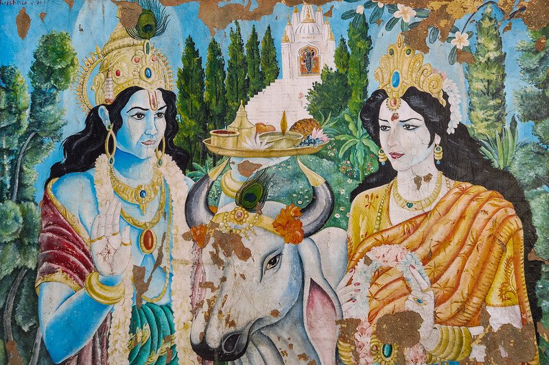 Colorful Hindu mural of Lord Krishna and goddess Radha with a sacred cow at Pashupatinath Temple in Kathmandu, Nepal, showing devotional art and religious symbolism
