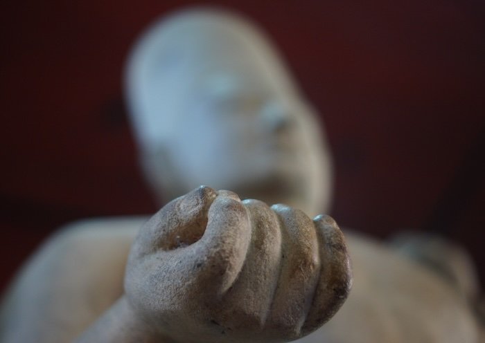 Close-up of an ancient Khmer statue’s hand at the National Museum of Cambodia in Phnom Penh, highlighting the intricate craftsmanship and historic artistry of Cambodian culture