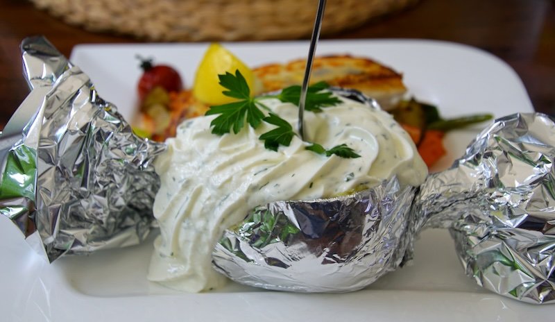 Potato with sour cream and grilled fish in Spreewald, Germany Potato with sour cream and grilled fish in Spreewald, Germany