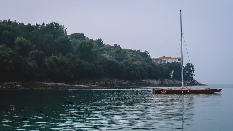 Pula low season with desolate beaches and slightly overcast but still beautiful with a view of a boat 