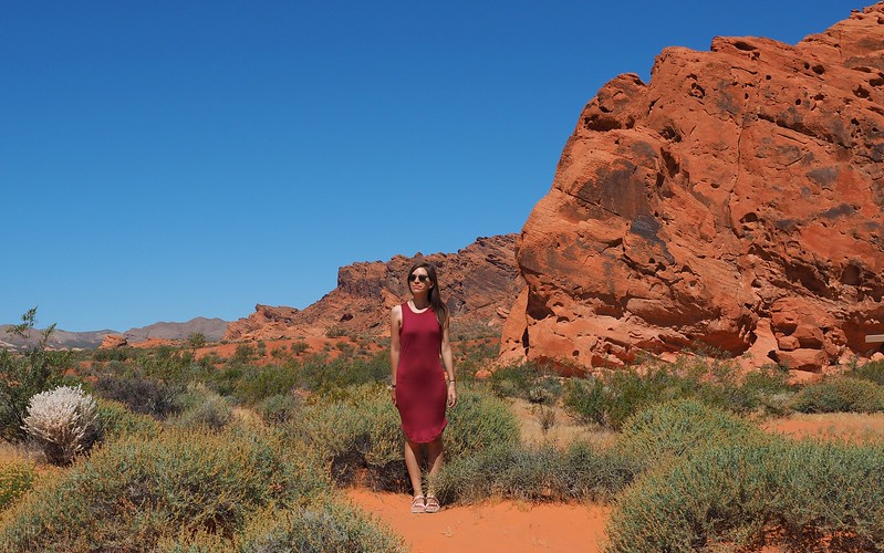 Red desert landscapes in Valley of Fire is one of the many places to visit in Nevada for nature with That Backpacker Audrey Bergner posing