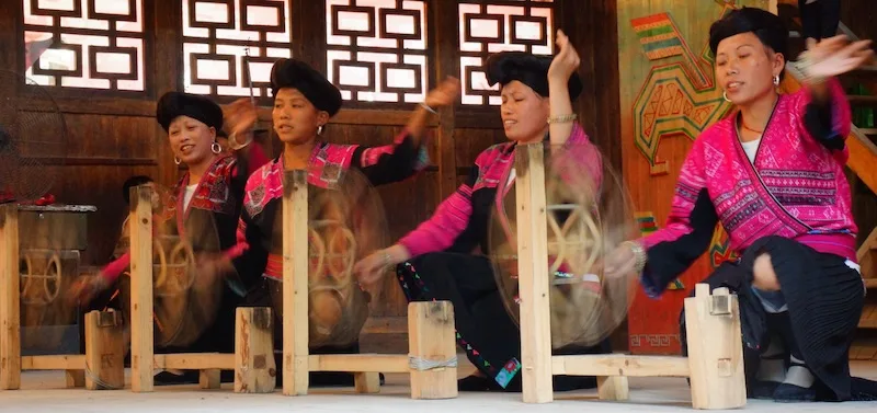Red Yao lady spinning performance on stage as a day trip from Guilin to Longji, China 