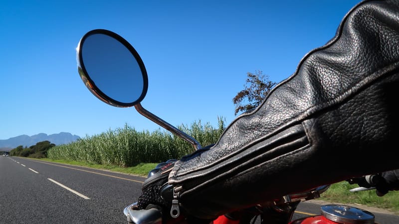 Riding a sidecar in Stellenbosch with macro views of our driver wearing a leather jacket and the rearview mirror in South Africa