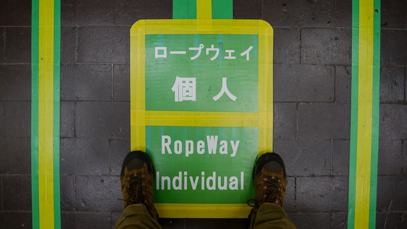 Ropeway Individual sign with Nomadic Samuel's feet on the ground in Tateyama Kurobe Alpine Crossing in Japan 